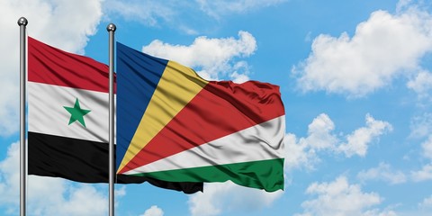 Syria and Seychelles flag waving in the wind against white cloudy blue sky together. Diplomacy concept, international relations.