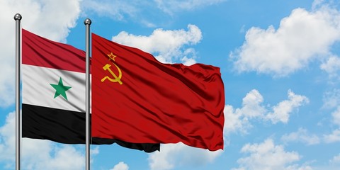 Syria and Soviet Union flag waving in the wind against white cloudy blue sky together. Diplomacy...