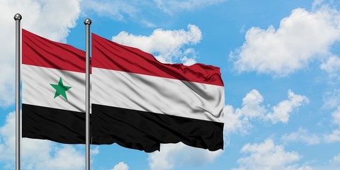 Syria and Yemen flag waving in the wind against white cloudy blue sky together. Diplomacy concept, international relations.