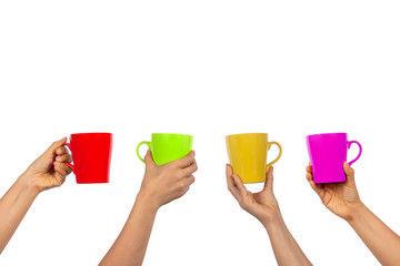 Many different women hands holding colorful mug of beverage isolated on white background.