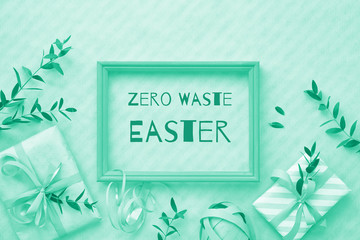 Flat lay monochrome image toned in trendy biscay green color. Flat lay background with wrapped gift boxes decorated with eucalyptus twigs.Text 