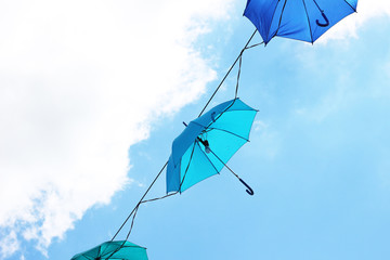 Colorful umbrellas against the blue sky and clouds