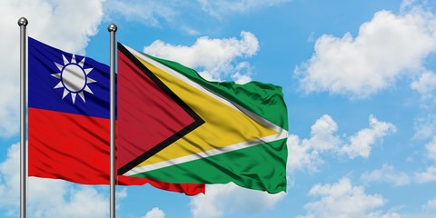 Taiwan and Guyana flag waving in the wind against white cloudy blue sky together. Diplomacy concept, international relations.