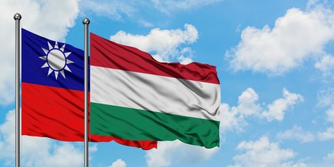 Naklejka na ściany i meble Taiwan and Hungary flag waving in the wind against white cloudy blue sky together. Diplomacy concept, international relations.