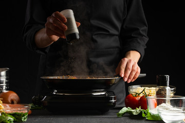 Chef fries vegetables with meat for cooking a delicious dish. Peppers. Restaurant business and fast...