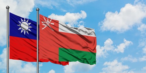 Taiwan and Oman flag waving in the wind against white cloudy blue sky together. Diplomacy concept, international relations.
