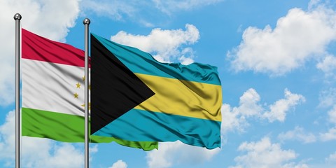 Tajikistan and Bahamas flag waving in the wind against white cloudy blue sky together. Diplomacy concept, international relations.