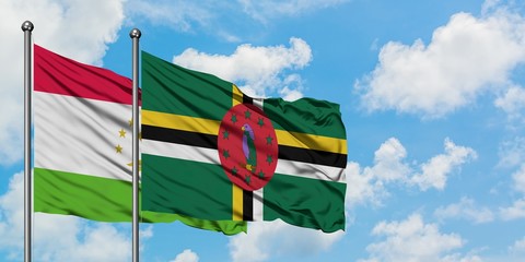 Tajikistan and Dominica flag waving in the wind against white cloudy blue sky together. Diplomacy...