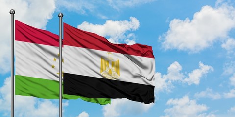 Tajikistan and Egypt flag waving in the wind against white cloudy blue sky together. Diplomacy concept, international relations.