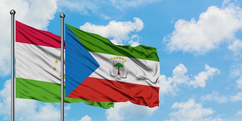 Tajikistan and Equatorial Guinea flag waving in the wind against white cloudy blue sky together. Diplomacy concept, international relations.