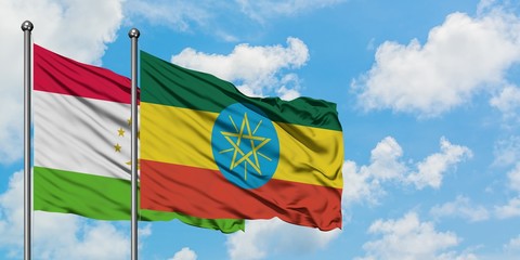 Tajikistan and Ethiopia flag waving in the wind against white cloudy blue sky together. Diplomacy concept, international relations.