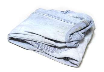 Stack of various old jeans on white background.