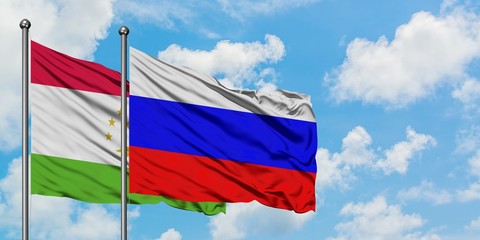 Tajikistan and Russia flag waving in the wind against white cloudy blue sky together. Diplomacy concept, international relations.