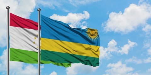 Tajikistan and Rwanda flag waving in the wind against white cloudy blue sky together. Diplomacy concept, international relations.