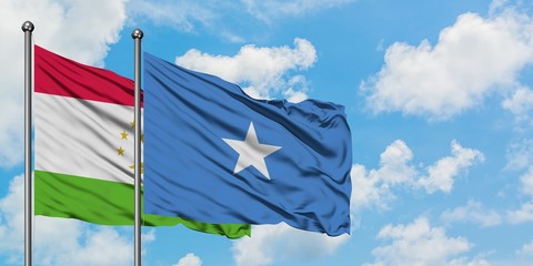 Tajikistan and Somalia flag waving in the wind against white cloudy blue sky together. Diplomacy concept, international relations.