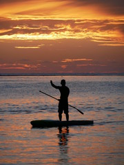 Silhouette d'homme début sur un paddle planche glonflabe