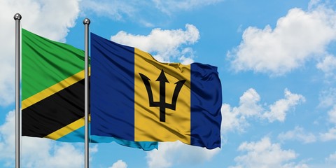 Tanzania and Barbados flag waving in the wind against white cloudy blue sky together. Diplomacy concept, international relations.