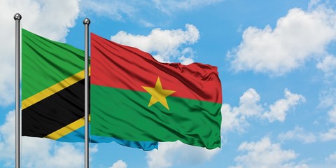 Tanzania and Burkina Faso flag waving in the wind against white cloudy blue sky together. Diplomacy concept, international relations.