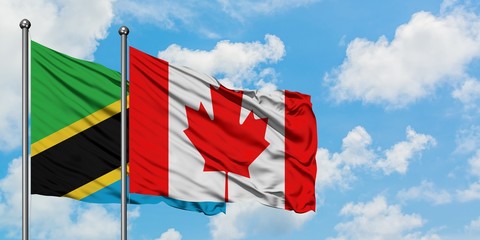 Tanzania and Canada flag waving in the wind against white cloudy blue sky together. Diplomacy concept, international relations.