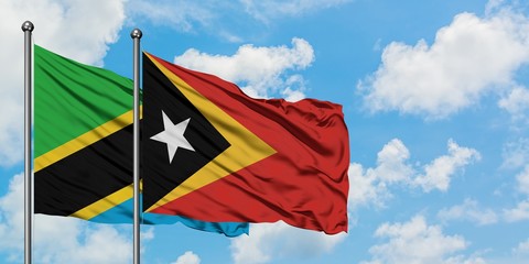 Tanzania and East Timor flag waving in the wind against white cloudy blue sky together. Diplomacy concept, international relations.