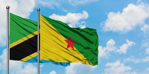 Tanzania and French Guiana flag waving in the wind against white cloudy blue sky together. Diplomacy concept, international relations.