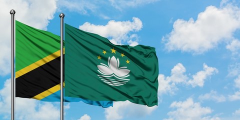 Tanzania and Macao flag waving in the wind against white cloudy blue sky together. Diplomacy concept, international relations.