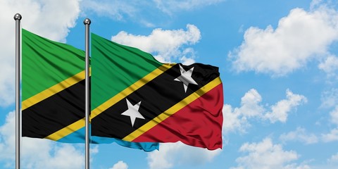 Tanzania and Saint Kitts And Nevis flag waving in the wind against white cloudy blue sky together. Diplomacy concept, international relations.