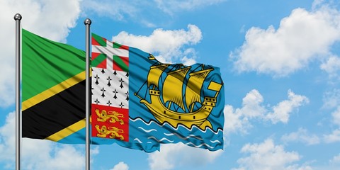 Tanzania and Saint Pierre And Miquelon flag waving in the wind against white cloudy blue sky together. Diplomacy concept, international relations.