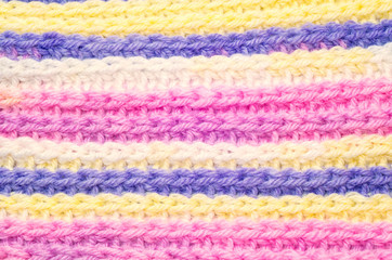 Blue, yellow, pink and white stripy knitted scarf texture.