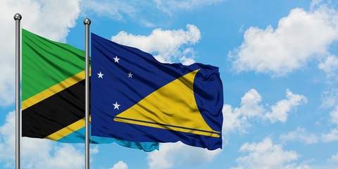 Tanzania and Tokelau flag waving in the wind against white cloudy blue sky together. Diplomacy concept, international relations.