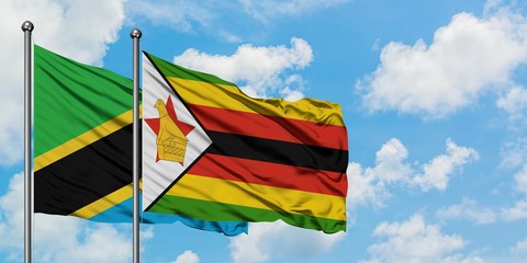 Tanzania and Zimbabwe flag waving in the wind against white cloudy blue sky together. Diplomacy concept, international relations.