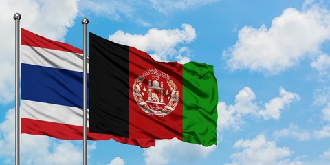 Thailand and Afghanistan flag waving in the wind against white cloudy blue sky together. Diplomacy...