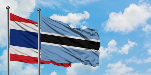 Thailand and Botswana flag waving in the wind against white cloudy blue sky together. Diplomacy concept, international relations.