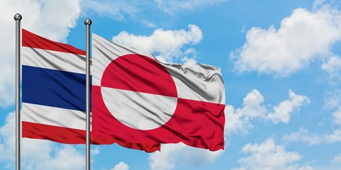 Thailand and Greenland flag waving in the wind against white cloudy blue sky together. Diplomacy concept, international relations.