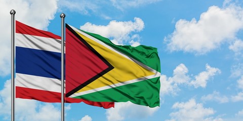 Thailand and Guyana flag waving in the wind against white cloudy blue sky together. Diplomacy concept, international relations.