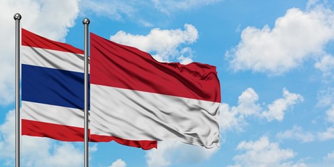 Thailand and Indonesia flag waving in the wind against white cloudy blue sky together. Diplomacy concept, international relations.
