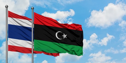 Thailand and Libya flag waving in the wind against white cloudy blue sky together. Diplomacy concept, international relations.