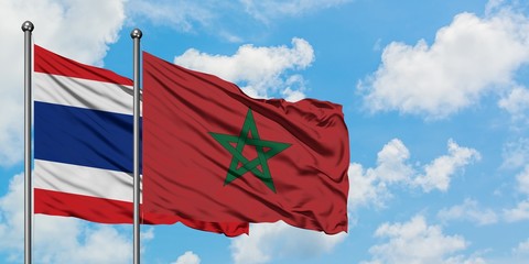 Thailand and Morocco flag waving in the wind against white cloudy blue sky together. Diplomacy concept, international relations.