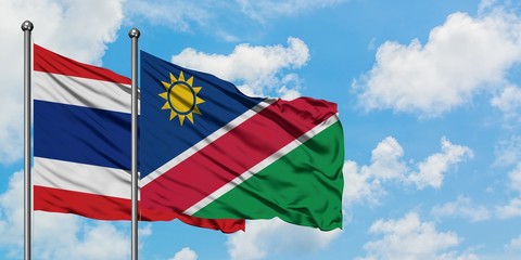 Thailand and Namibia flag waving in the wind against white cloudy blue sky together. Diplomacy concept, international relations.