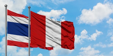 Thailand and Peru flag waving in the wind against white cloudy blue sky together. Diplomacy concept, international relations.