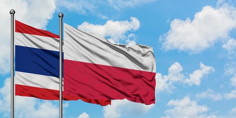 Thailand and Poland flag waving in the wind against white cloudy blue sky together. Diplomacy concept, international relations.
