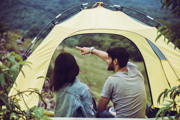 Enjoying camping couple lover sitting in tent together