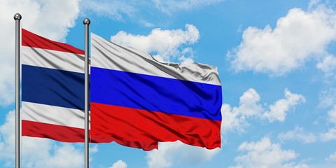 Thailand and Russia flag waving in the wind against white cloudy blue sky together. Diplomacy concept, international relations.