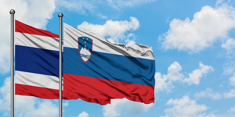 Thailand and Slovenia flag waving in the wind against white cloudy blue sky together. Diplomacy concept, international relations.