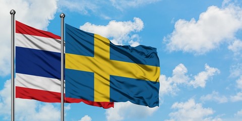 Thailand and Sweden flag waving in the wind against white cloudy blue sky together. Diplomacy concept, international relations.