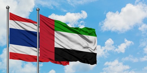 Thailand and United Arab Emirates flag waving in the wind against white cloudy blue sky together. Diplomacy concept, international relations.