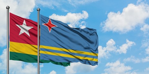Togo and Aruba flag waving in the wind against white cloudy blue sky together. Diplomacy concept, international relations.