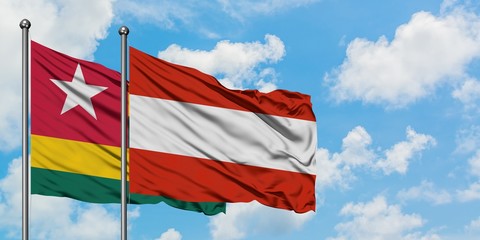 Togo and Austria flag waving in the wind against white cloudy blue sky together. Diplomacy concept, international relations.