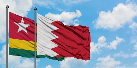 Togo and Bahrain flag waving in the wind against white cloudy blue sky together. Diplomacy concept, international relations.