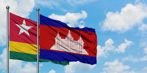 Togo and Cambodia flag waving in the wind against white cloudy blue sky together. Diplomacy...